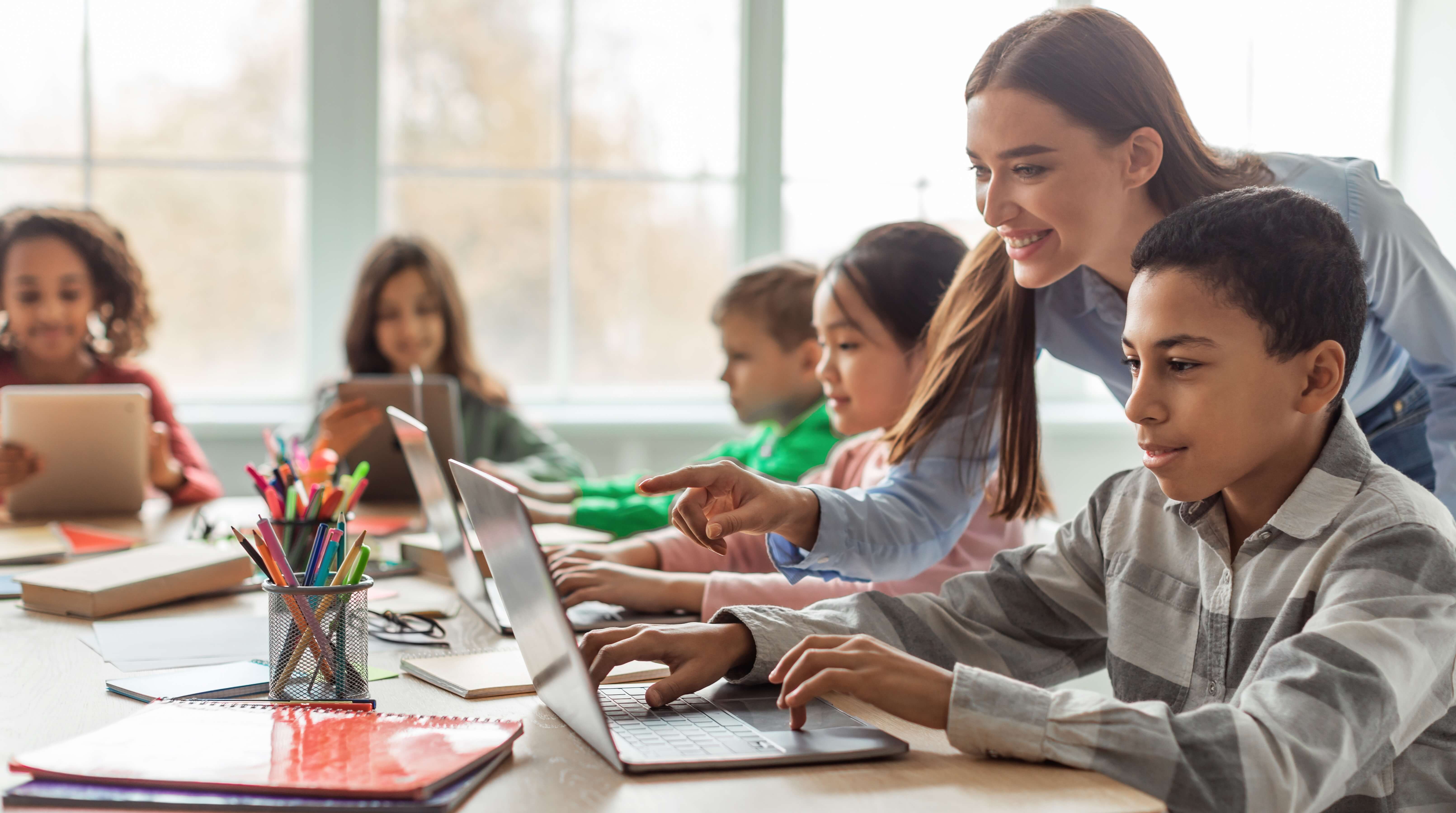 female ECT helping a student use their laptop